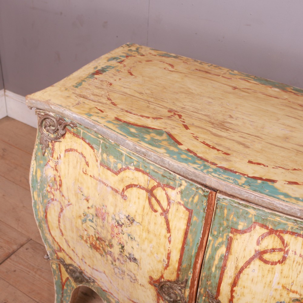 A Venetian serpentine painted wooden buffet cabinet featuring hand-painted floral cartouches, a polychrome green and cream finish, and metal corner mounts. View VII