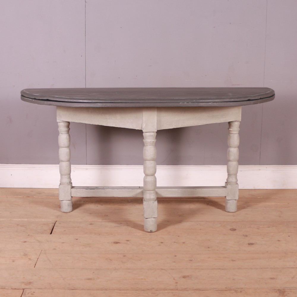 A semi-circular painted Dutch console table with a grey top, off-white apron, turned legs, and a lower stretcher base.