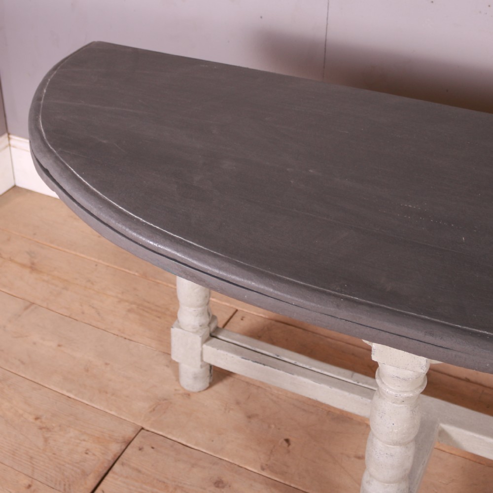 A semi-circular painted Dutch console table with a grey top, off-white apron, turned legs, and a lower stretcher base. View III