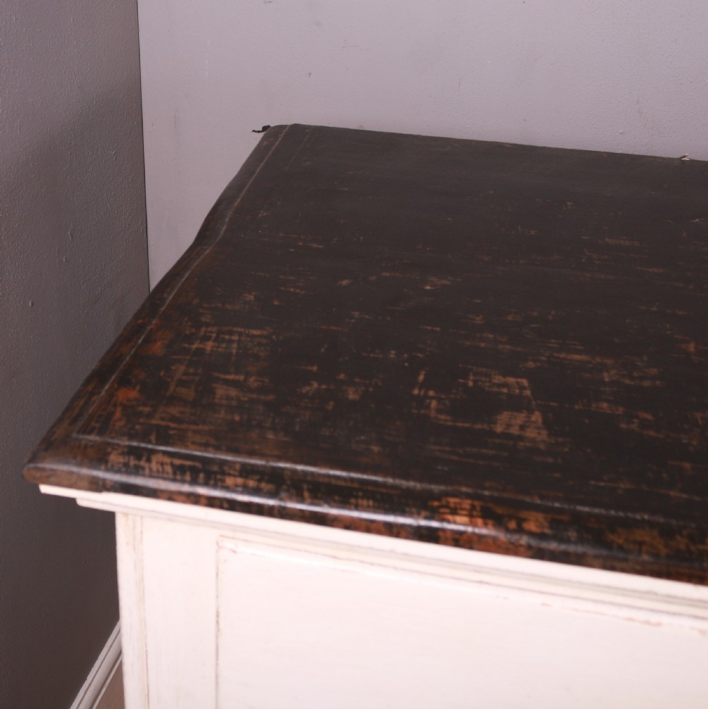 A long off-white painted French bank of drapers drawers featuring ten large drawers with wooden handles and a dark stained top surface. View VII