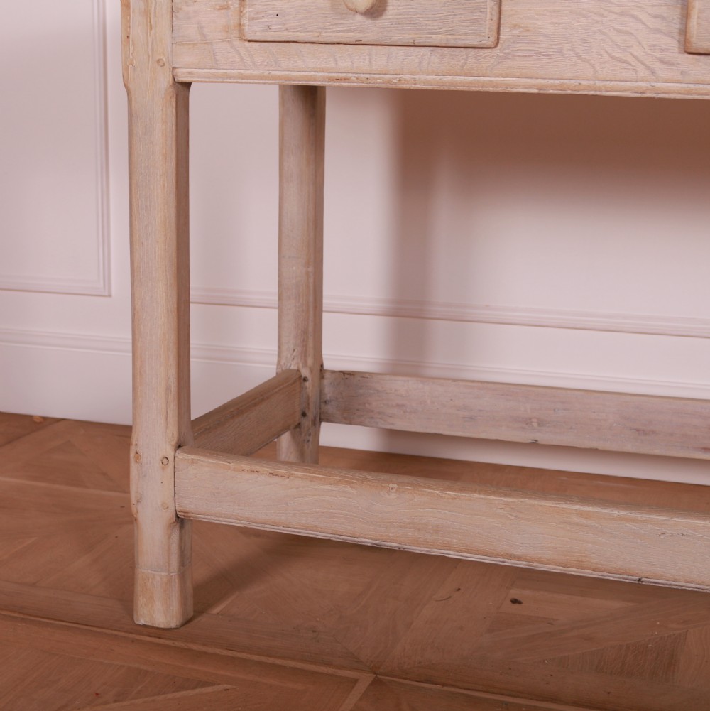 A long bleached oak serving table with five drawers, turned wooden knobs, square legs, and a low stretcher frame. View VII