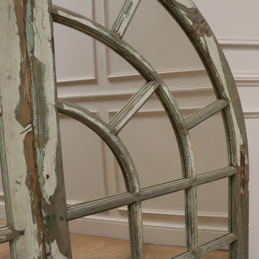 A large semi-circular arched architectural window frame with distressed green paint finish converted into a multi-pane mirror. View VI