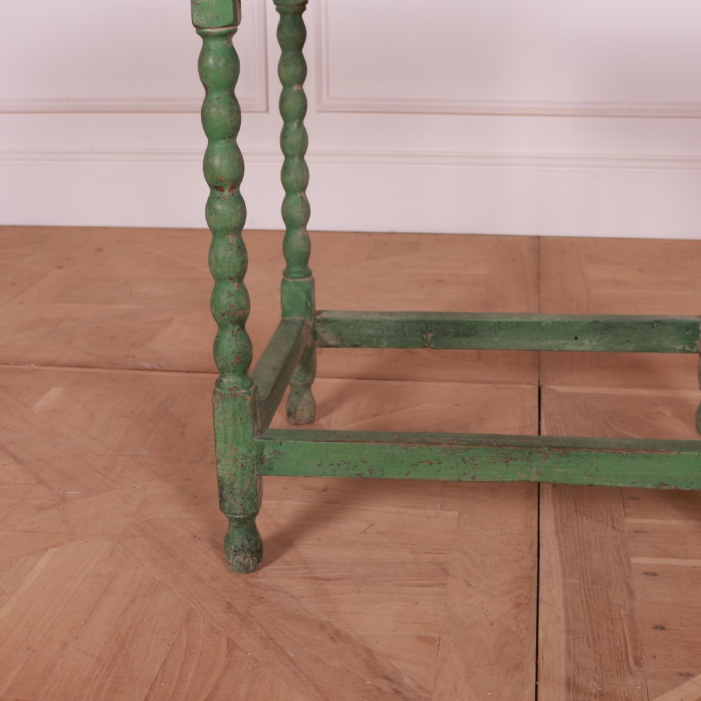 An 18th-century green painted wooden lamp table featuring four bobbin-turned legs, a rectangular top, lower stretchers, and a single drawer with a brass drop handle. View III