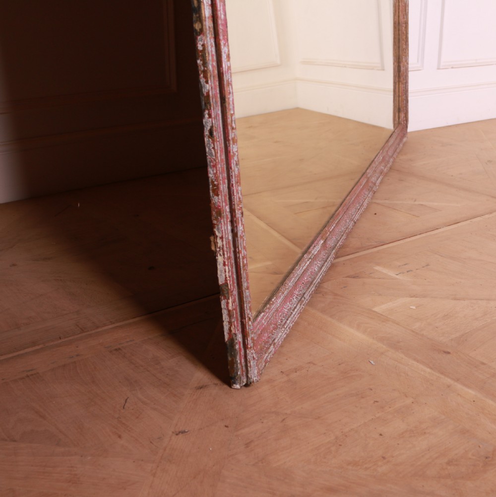 A large rectangular floor-leaning mirror featuring a distressed reddish-brown painted wooden frame and a clear reflective plate. View V