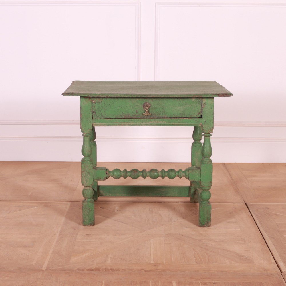 An 18th-century English painted green side table featuring a rectangular top, single drawer with brass escutcheon, turned legs, and a bobbin stretcher.