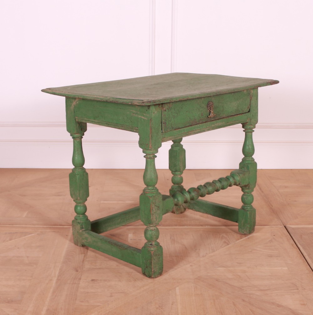 An 18th-century English painted green side table featuring a rectangular top, single drawer with brass escutcheon, turned legs, and a bobbin stretcher. View VII