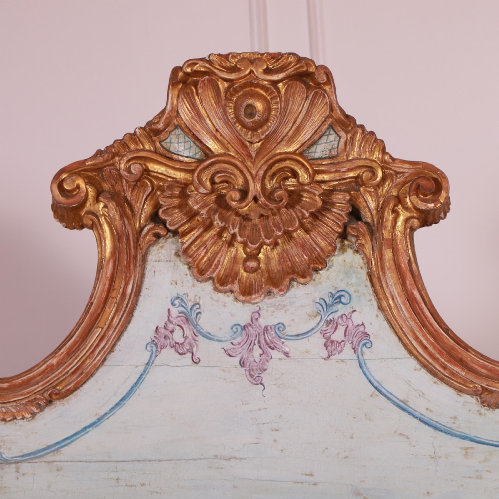 An 18th-century Italian painted credenza featuring four floral-panel doors, giltwood mouldings, and a matching stepped shelf structure mounted above. View VIII