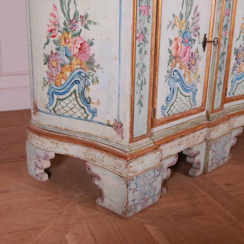 An 18th-century Italian painted credenza featuring four floral-panel doors, giltwood mouldings, and a matching stepped shelf structure mounted above. View XI