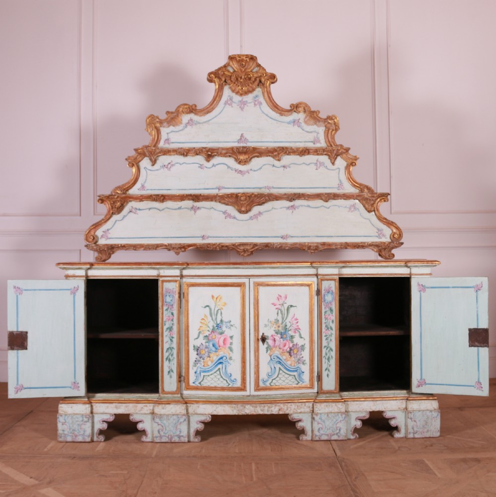 An 18th-century Italian painted credenza featuring four floral-panel doors, giltwood mouldings, and a matching stepped shelf structure mounted above. View XIII