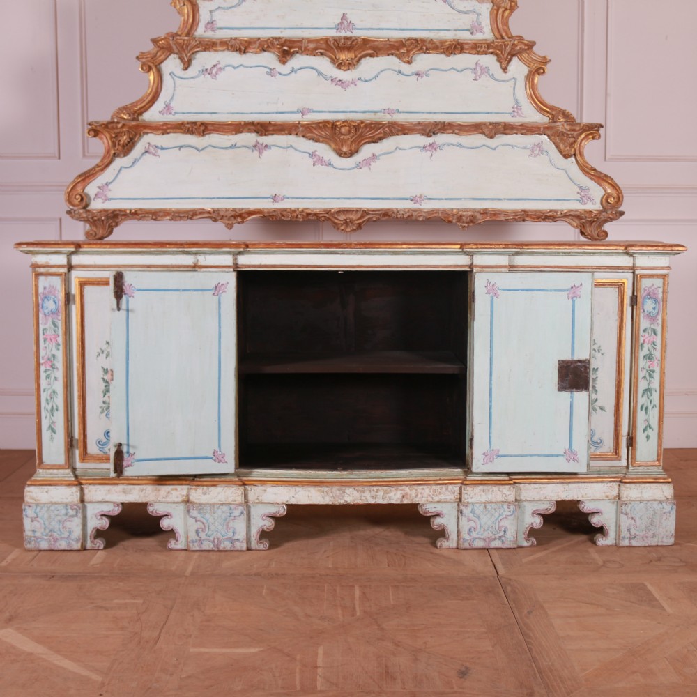 An 18th-century Italian painted credenza featuring four floral-panel doors, giltwood mouldings, and a matching stepped shelf structure mounted above. View XIV