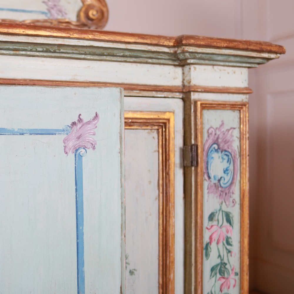 An 18th-century Italian painted credenza featuring four floral-panel doors, giltwood mouldings, and a matching stepped shelf structure mounted above. View XV