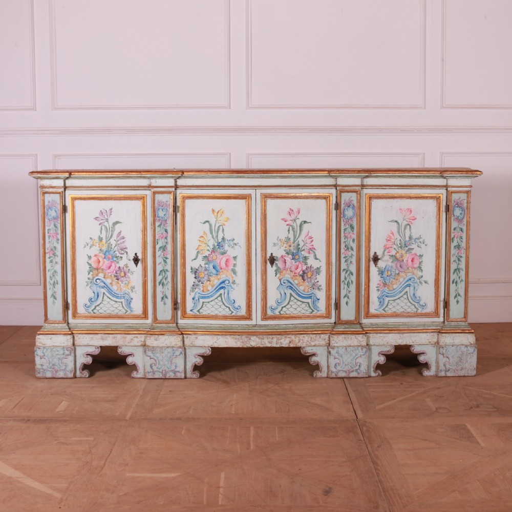 An 18th-century Italian painted credenza featuring four floral-panel doors, giltwood mouldings, and a matching stepped shelf structure mounted above. View XIX
