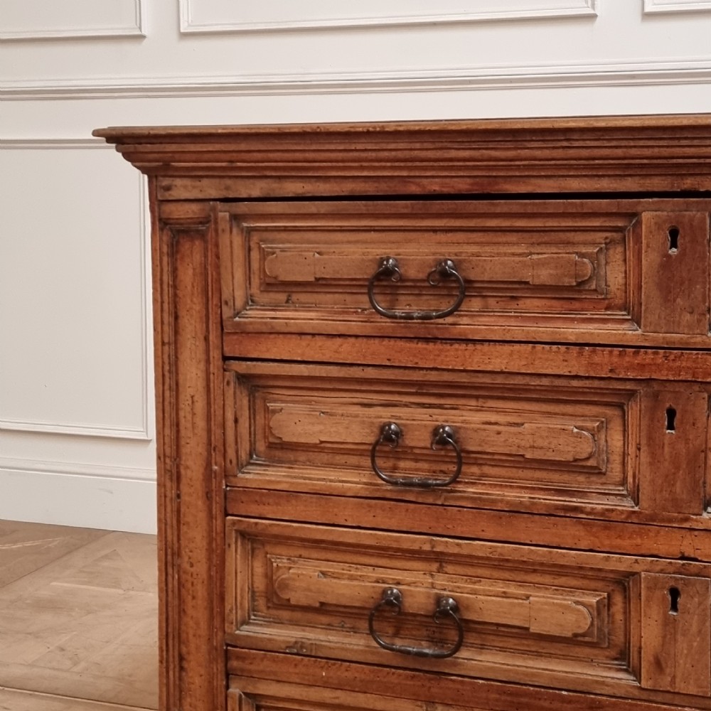 An 18th-century Italian walnut commode featuring four long drawers with geometric raised panel mouldings, iron drop handles, and octagonal feet. View II