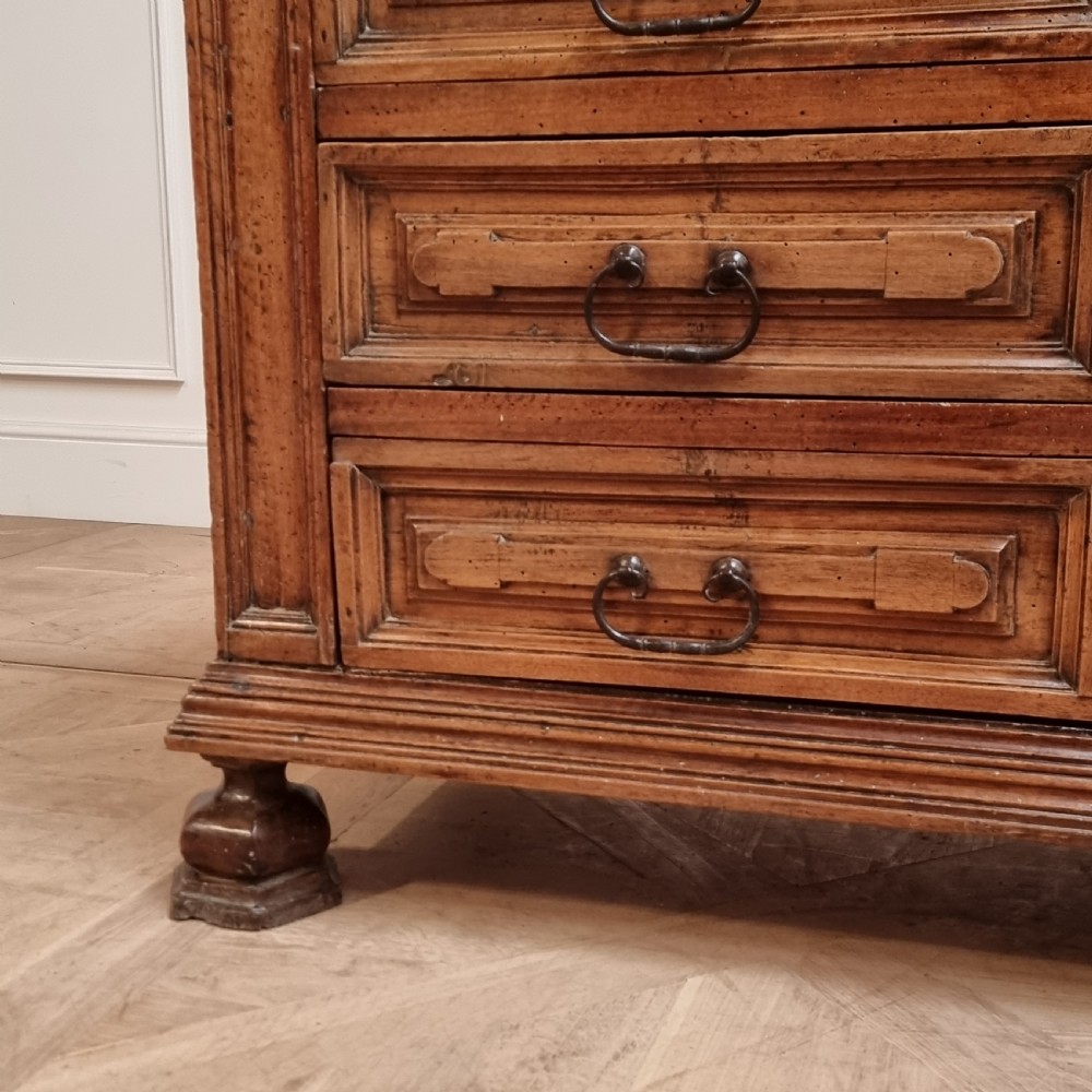 An 18th-century Italian walnut commode featuring four long drawers with geometric raised panel mouldings, iron drop handles, and octagonal feet. View III