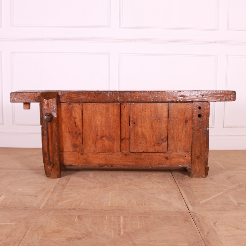 A rustic French primitive timber workbench with an integrated wooden vice mechanism and a thick slab top. View IV