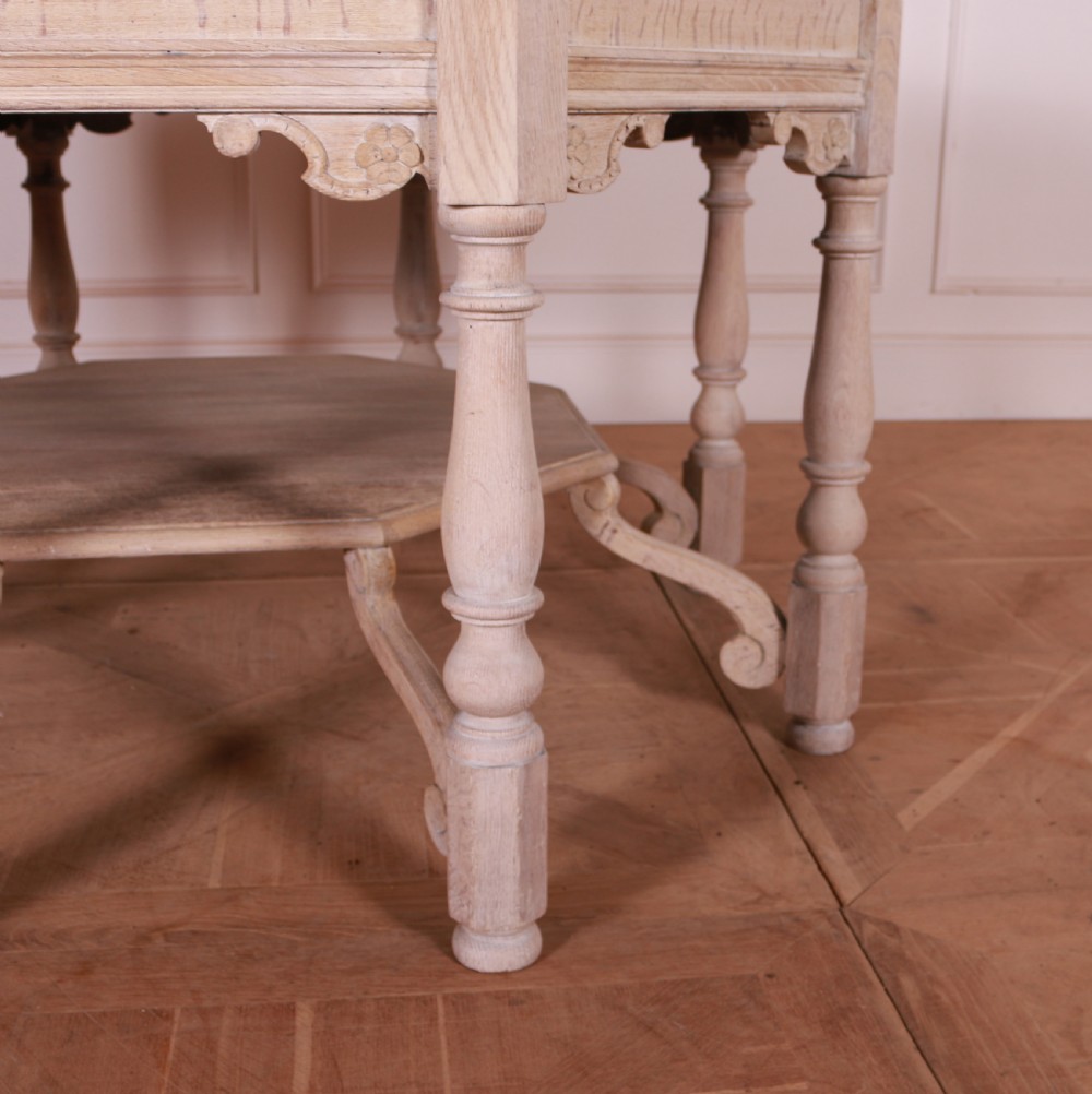 An octagonal bleached oak centre table featuring turned legs, a lower shelf, and decorative carved aprons. View III