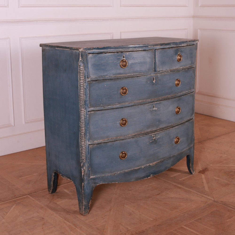 A blue painted bow-front chest of drawers featuring two small drawers over three long drawers with brass ring handles. View II