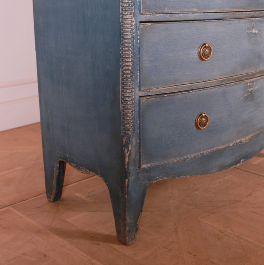 A blue painted bow-front chest of drawers featuring two small drawers over three long drawers with brass ring handles. View III