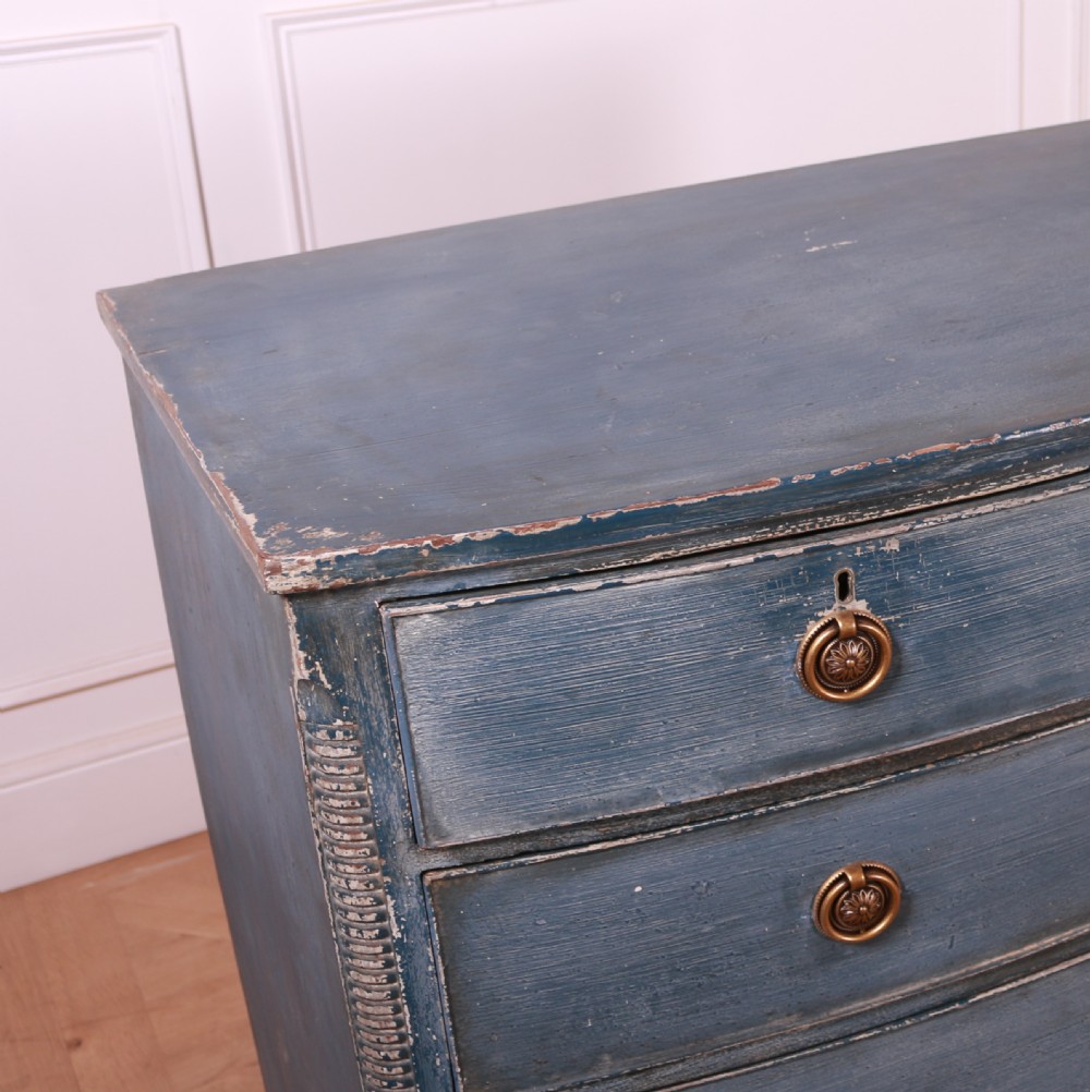 A blue painted bow-front chest of drawers featuring two small drawers over three long drawers with brass ring handles. View VII