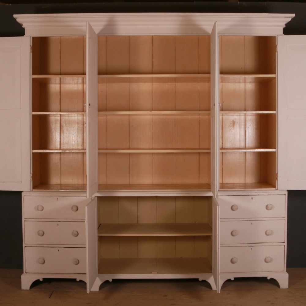 A large two-part off-white painted pine housekeepers cupboard with four upper fielded panel doors, six flanking drawers, and two central lower cabinet doors. View VII