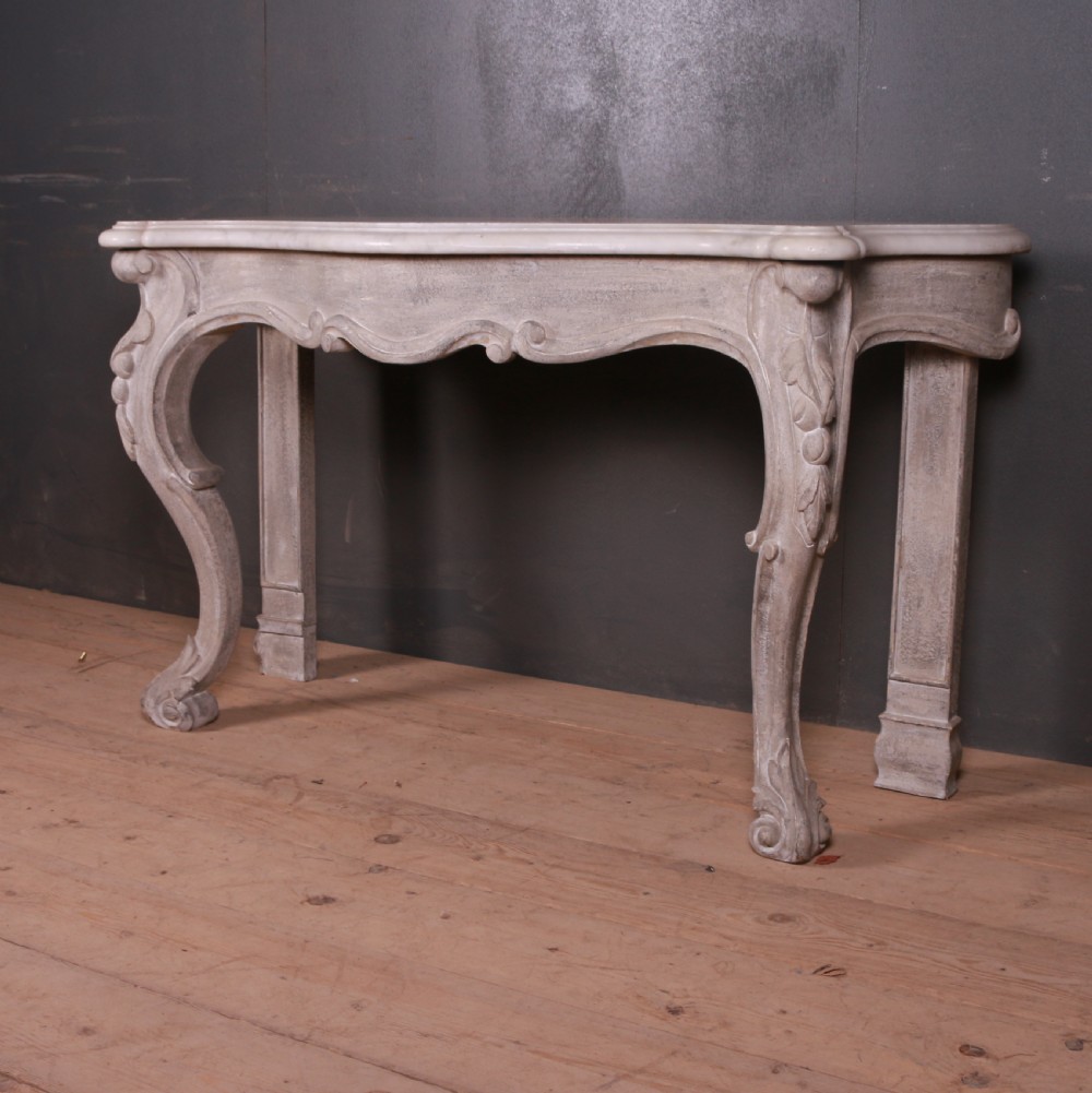 An off-white carved wooden console table with a serpentine white marble top and cabriole legs. View III
