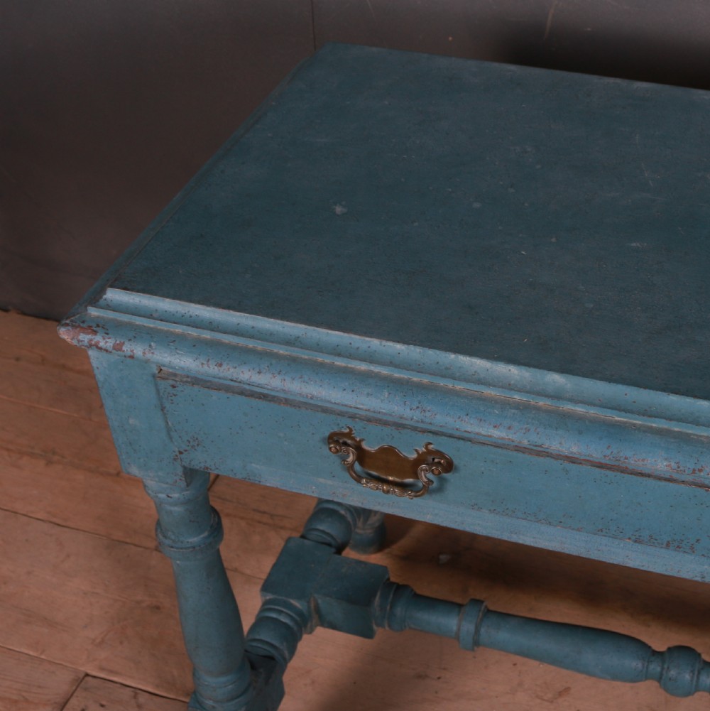 A blue painted side table featuring a single drawer with two brass handles, turned legs, and lower stretchers. View VI