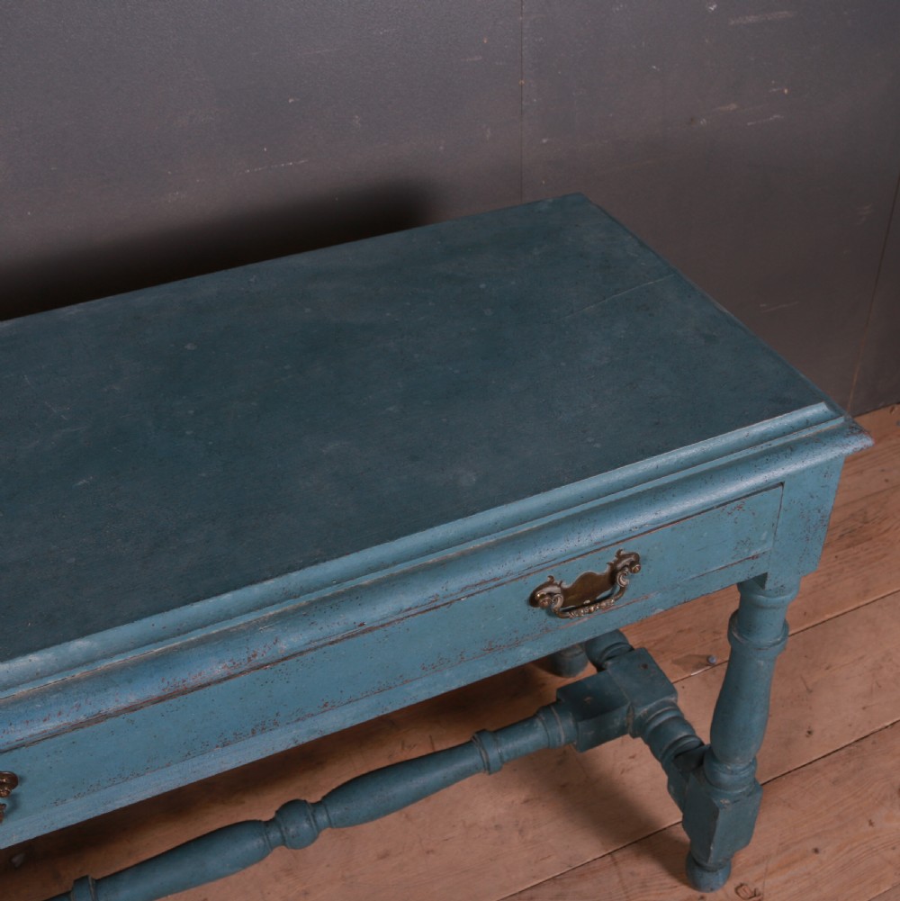 A blue painted side table featuring a single drawer with two brass handles, turned legs, and lower stretchers. View VII