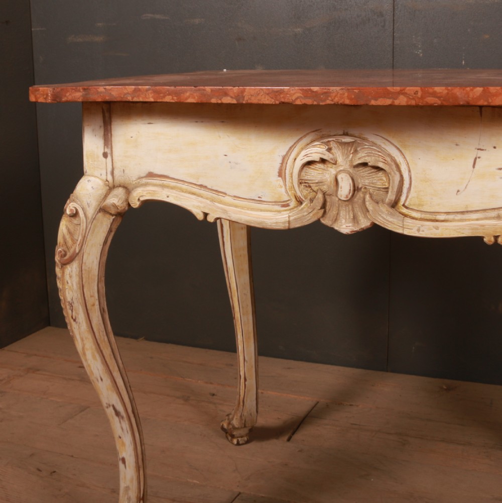 A Swedish Rococo style centre table featuring cream painted cabriole legs, carved apron motifs, and a reddish-brown marbled top. View II