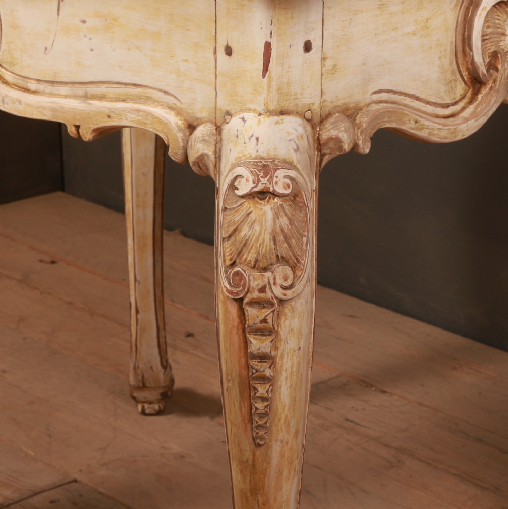 A Swedish Rococo style centre table featuring cream painted cabriole legs, carved apron motifs, and a reddish-brown marbled top. View IV