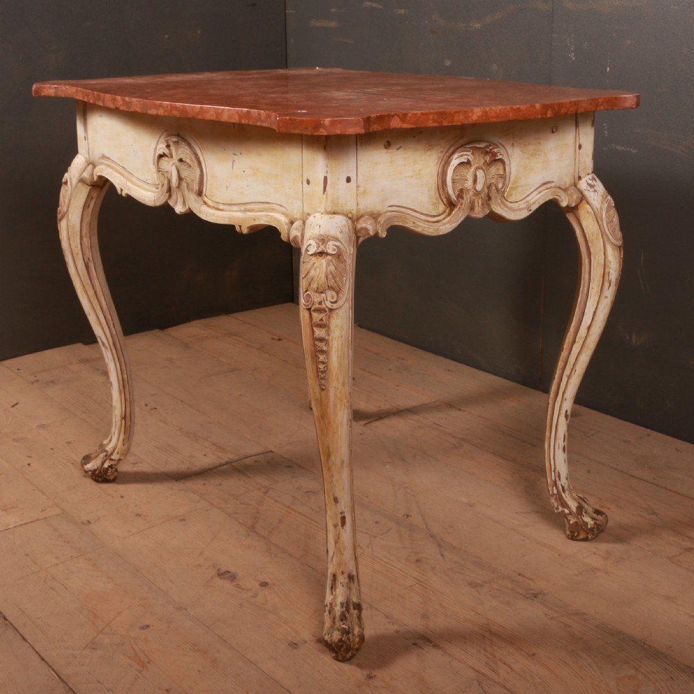 A Swedish Rococo style centre table featuring cream painted cabriole legs, carved apron motifs, and a reddish-brown marbled top. View V