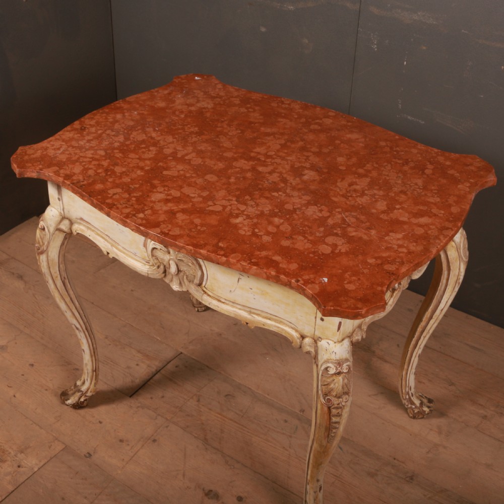 A Swedish Rococo style centre table featuring cream painted cabriole legs, carved apron motifs, and a reddish-brown marbled top. View VI