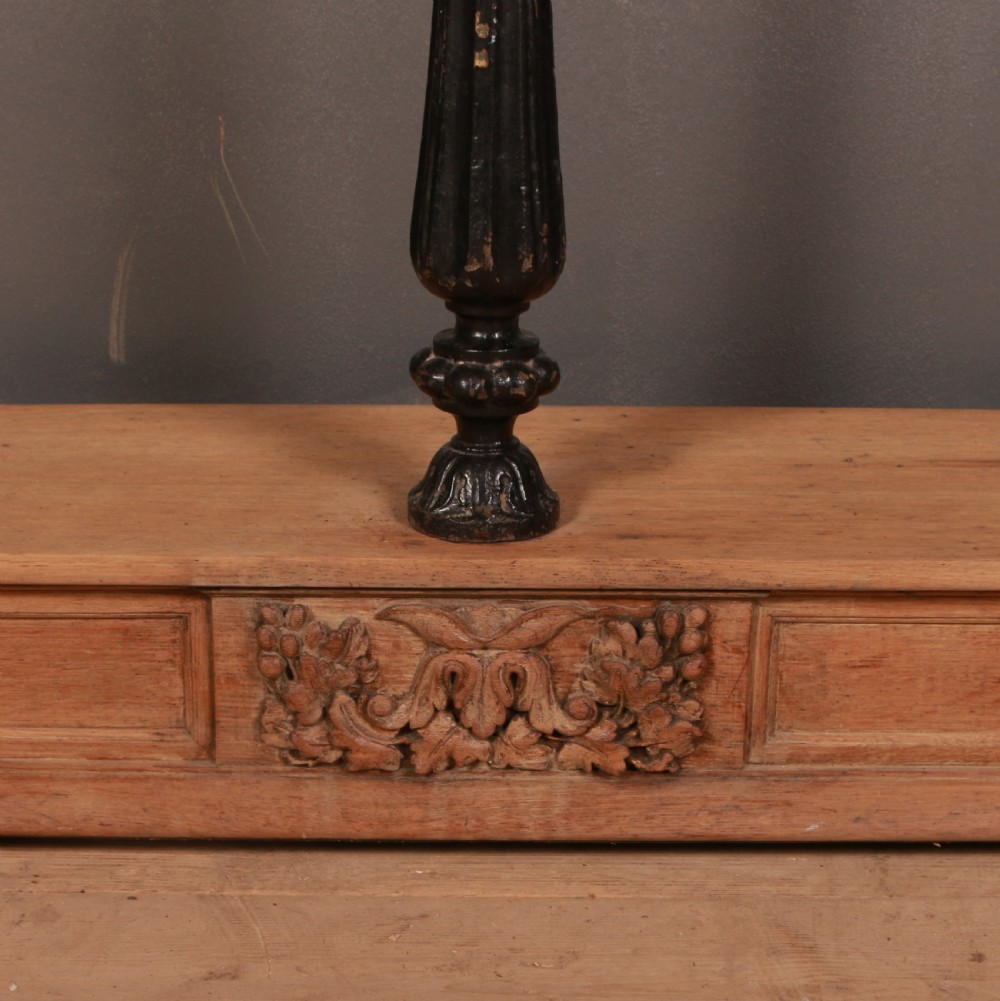 An antique bleached oak console table featuring a pediment backboard with a central carved motif, dark ebonised turned columns, and a carved lower plinth. View II