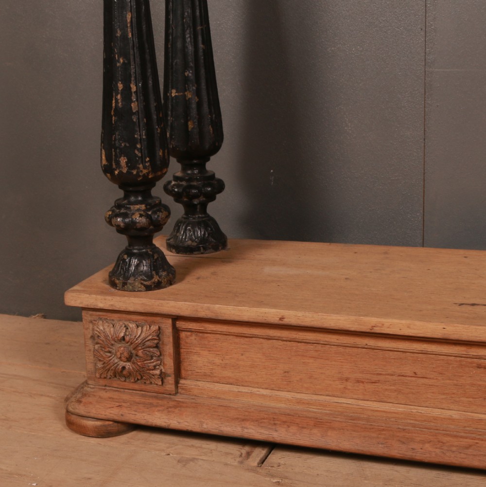 An antique bleached oak console table featuring a pediment backboard with a central carved motif, dark ebonised turned columns, and a carved lower plinth. View III