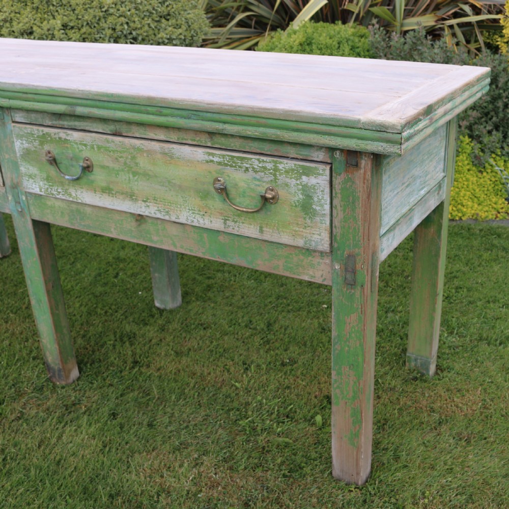 An exceptionally long antique English dresser base featuring a distressed green painted finish, multiple drawers with drop handles, and square legs. View II