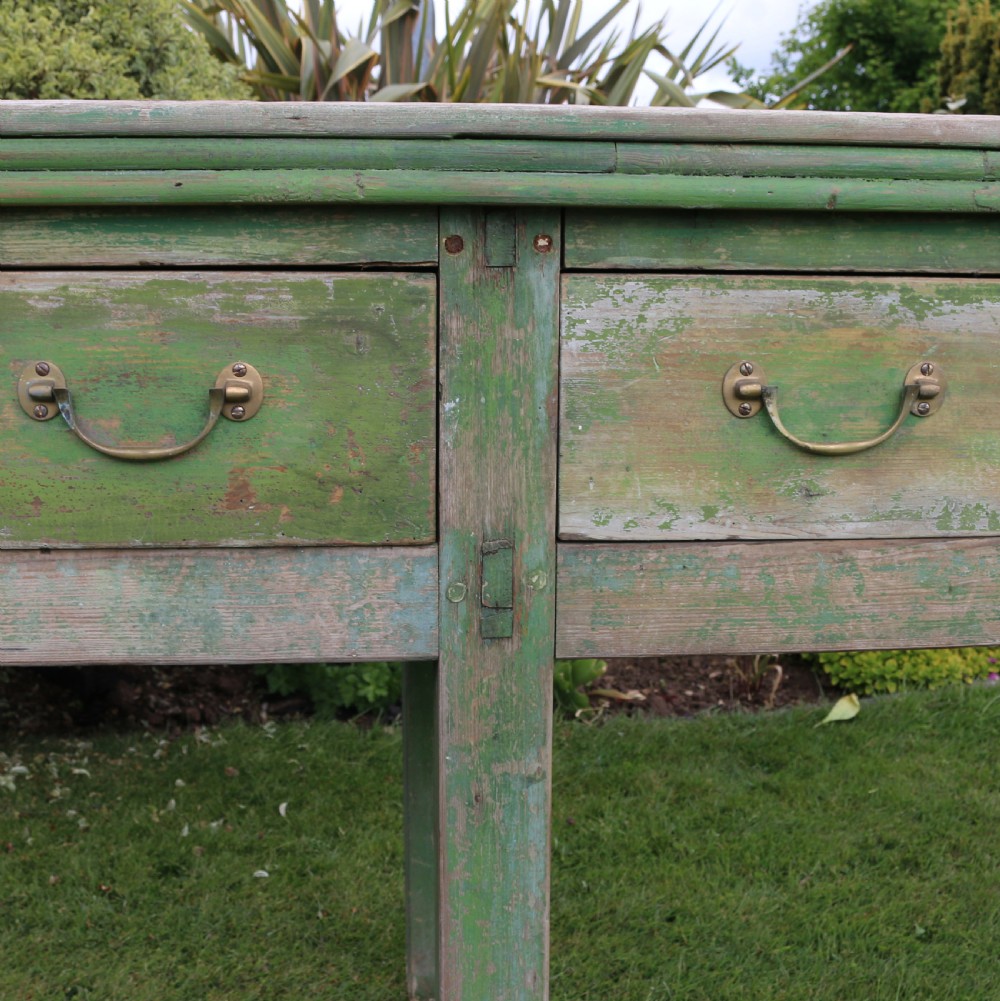 An exceptionally long antique English dresser base featuring a distressed green painted finish, multiple drawers with drop handles, and square legs. View IV