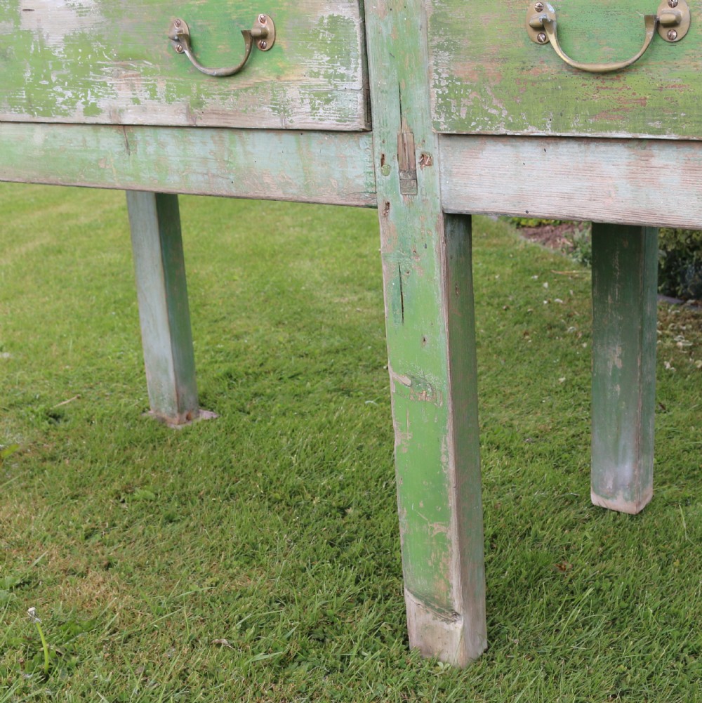 An exceptionally long antique English dresser base featuring a distressed green painted finish, multiple drawers with drop handles, and square legs. View V