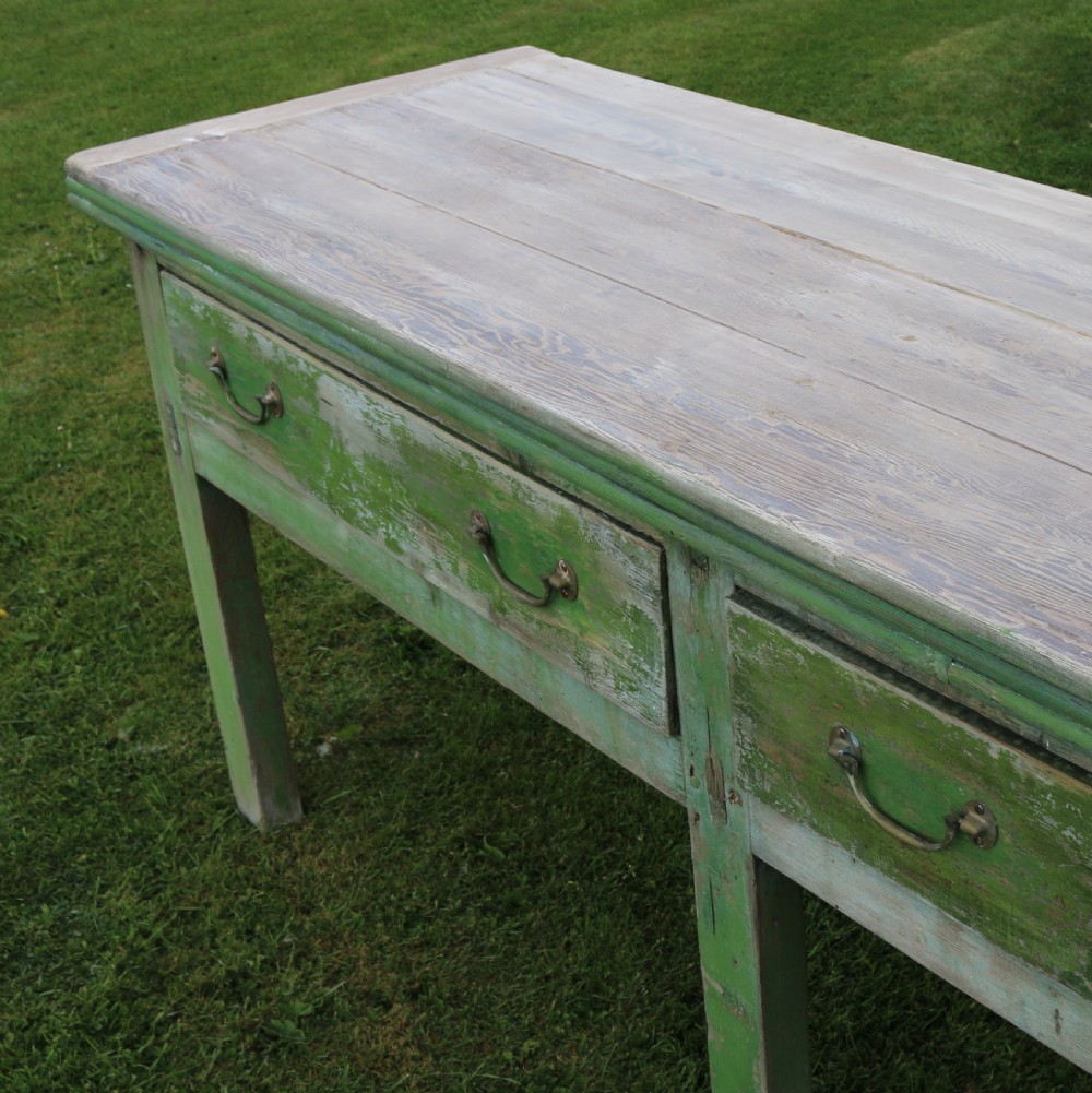 An exceptionally long antique English dresser base featuring a distressed green painted finish, multiple drawers with drop handles, and square legs. View VI