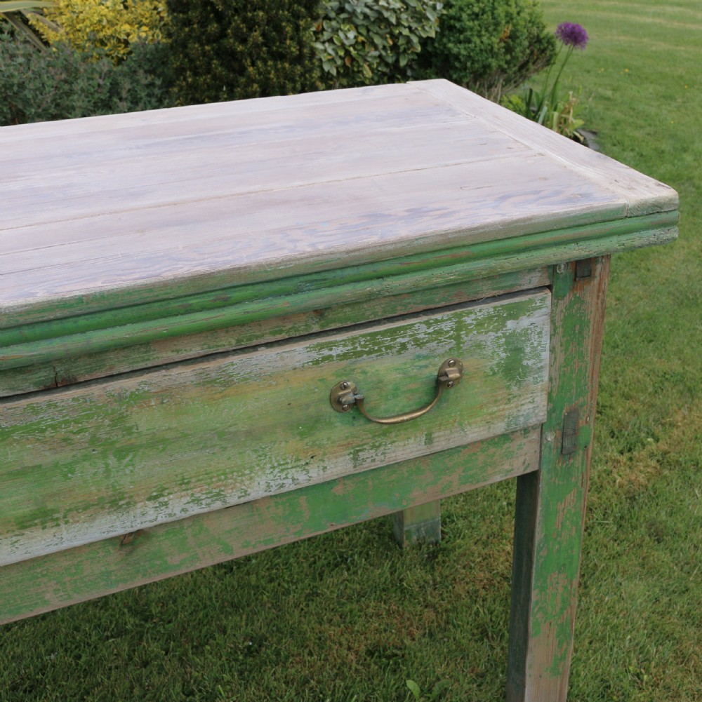 An exceptionally long antique English dresser base featuring a distressed green painted finish, multiple drawers with drop handles, and square legs. View IX