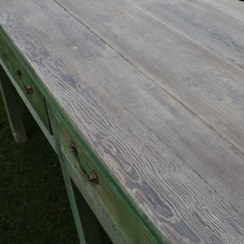 An exceptionally long antique English dresser base featuring a distressed green painted finish, multiple drawers with drop handles, and square legs. View X