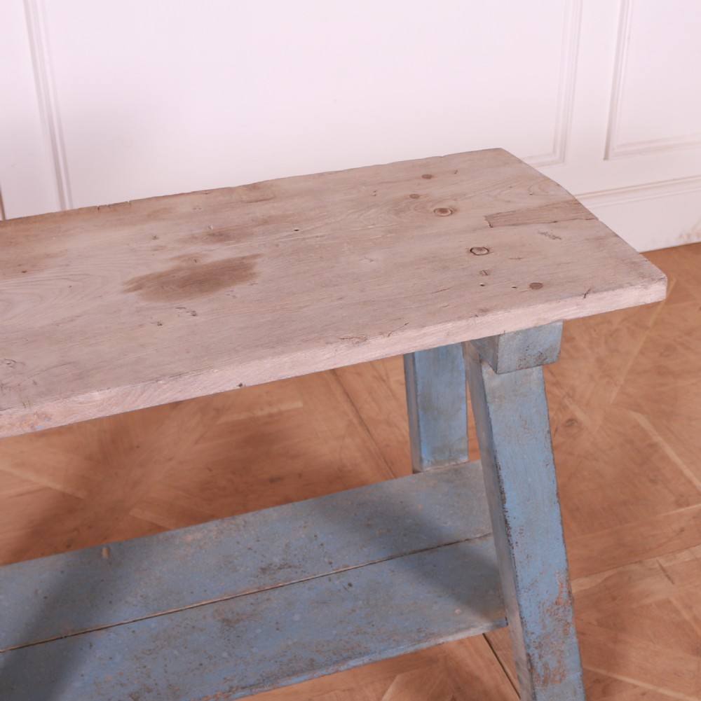 A rustic pine trestle table featuring a natural unpainted wood top and distressed blue painted A-frame legs with a lower storage shelf. View VI