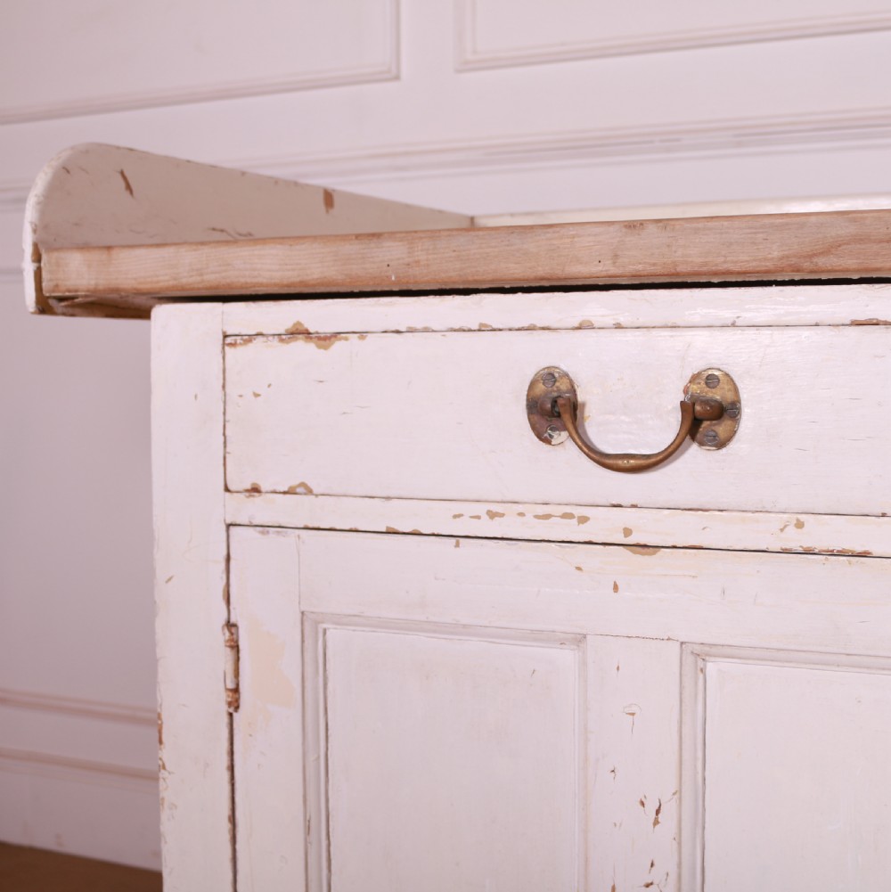 A Scottish painted pine dresser base with three top drawers over three panelled cupboard doors, featuring a natural timber top with a low gallery back and a distressed off-white painted finish. View VIII