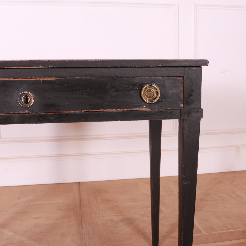 A rectangular black painted French side table featuring a single frieze drawer, brass handles, and square tapered legs. View III