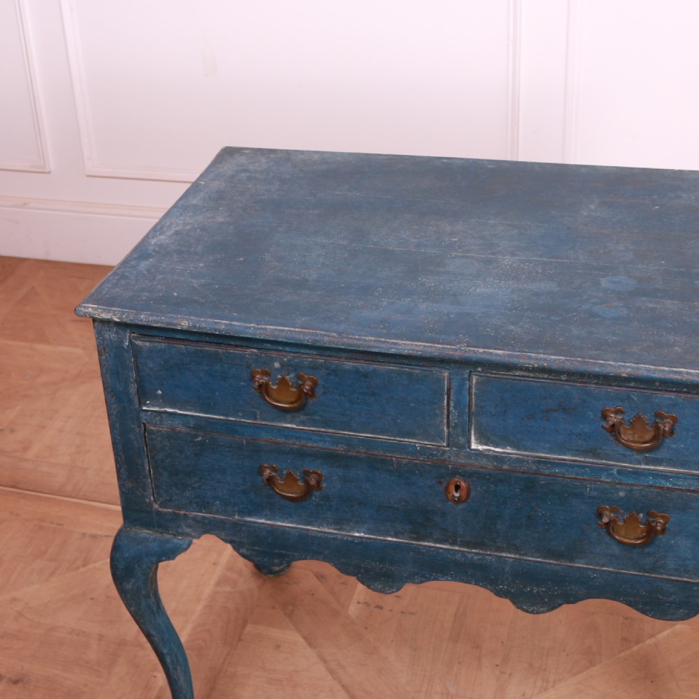 An eighteenth-century blue painted lowboy featuring three drawers with brass handles, a scalloped apron, and cabriole legs. View VI