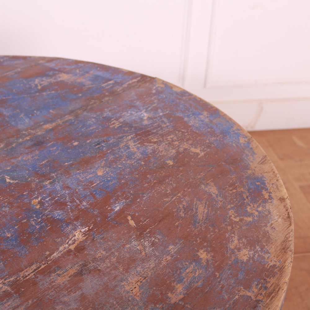 A round French provincial wooden dining table featuring a distressed blue painted finish over an exposed undercoat, supported by four square legs. View V