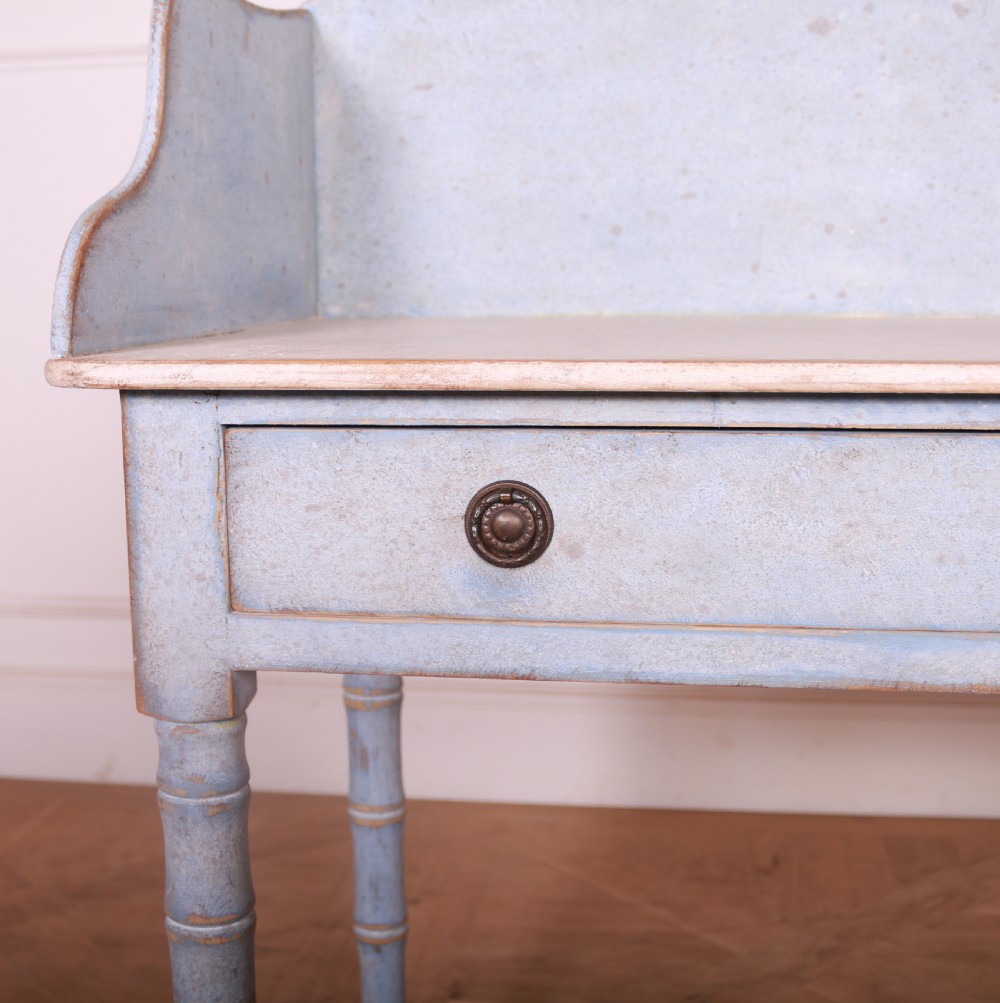 A pale blue painted side table featuring a raised gallery back, single drawer with two circular metal knobs, and ring-turned legs. View IX
