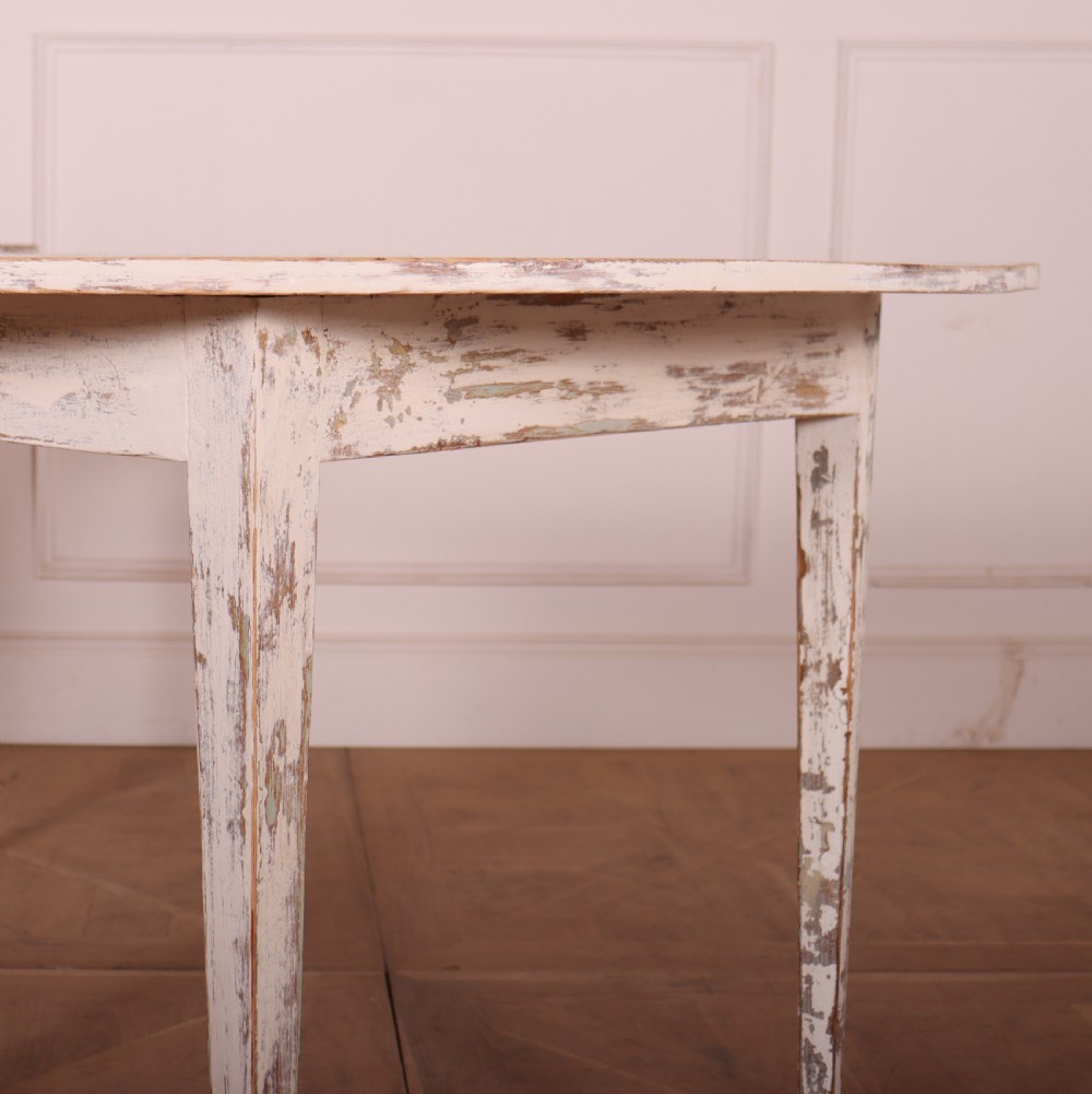 A pair of antique Swedish demi-lune console tables featuring distressed off-white painted finishes and simple tapered legs. View II