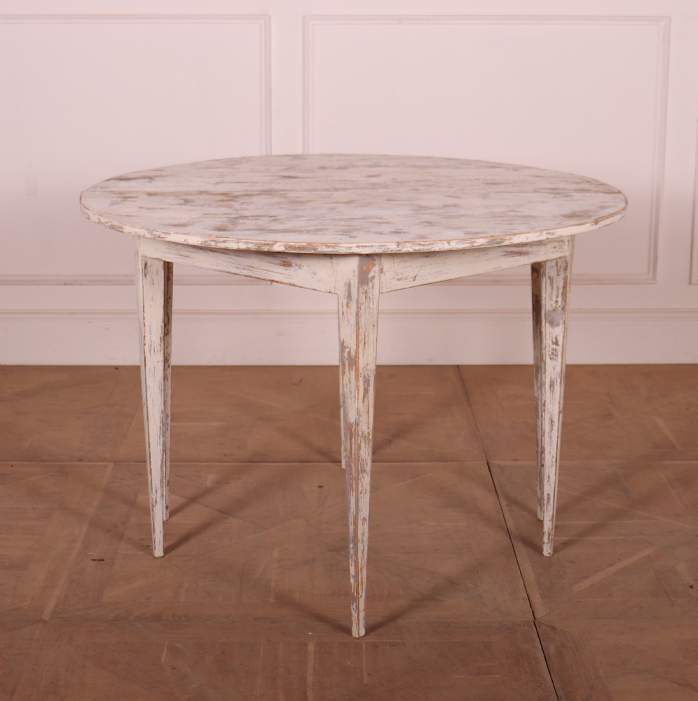 A pair of antique Swedish demi-lune console tables featuring distressed off-white painted finishes and simple tapered legs. View V