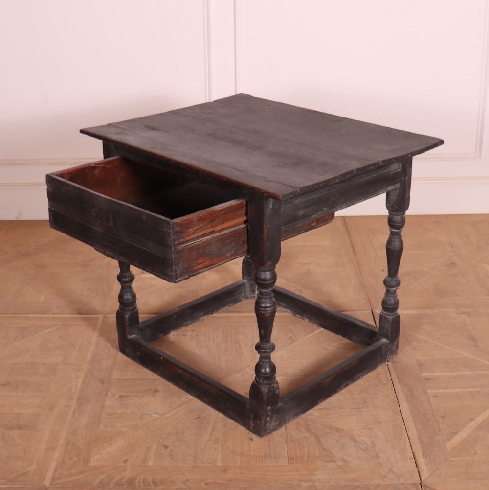 An 18th-century dark painted wooden side table with a single drawer, turned legs, and low box stretchers. View V
