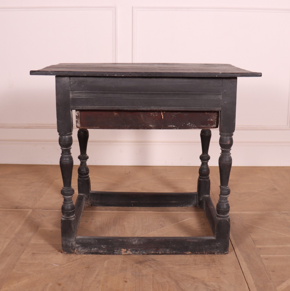 An 18th-century dark painted wooden side table with a single drawer, turned legs, and low box stretchers. View VI