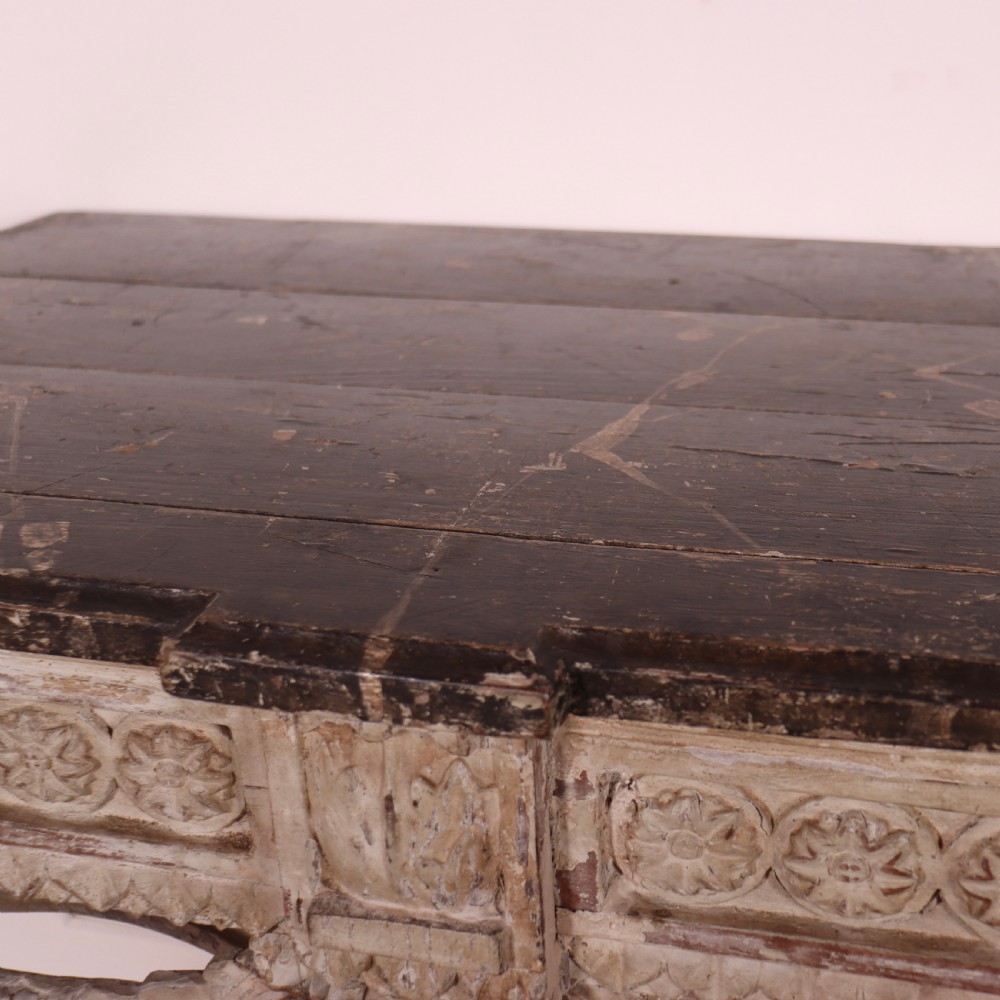 An 18th-century French carved wood console table featuring a dark top, rosette frieze, carved drapery swags, and a distressed off-white finish. View III